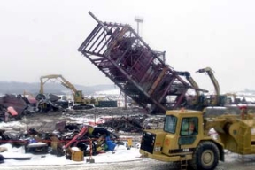 Operating Engineers Topple the Last Section of Plant 8 by Pushing the Structure to the Ground.
Plant 8, the Scrap Recovery Plant, recycled residues and scrap from the uranium production process. Ores, concentrates and process residues were roosted to oxidize the impurities and then filtered. The filtered material was converted to free flowing powder and transferred to Plant 2 for further processing. The D&D of the plants consists of surface decontamination, building and equipment dismantlement, size reduction of building material and the loading of demolition debris into rolloff boxes for transfer on the On-Site Disposal Facility. 
Keywords: Fernald Closure Project Fernald Green Salt Plant, Feed Materials Production Center, Fernald, Ohio (FEMP)