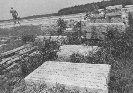 Low-level Radioactive Burial Markers
These granite markets sit at the back end of the ChemNuclear waste disposal site. Each is a headstone for a large clay trench containing metal drums, steel boxes, polyethylene containers, and carbon steel liners full of medical, industrial, and commercial radioactive waste. The "institutional control period" for the site is 100 years. Barnwell, South Carolina, August 7, 1983. 
Keywords: Barnwell