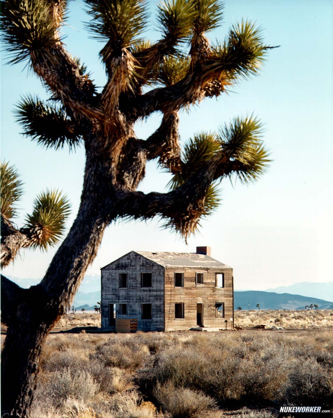 NF-4587 This "Survival Town" house
NF-4587 This "Survival Town" house, some 7,500 feet from a 29-kiloton nuclear detonation, remained essentially intact. Survival Town consisted of houses, office buildings, fallout shelters, power systems, communications equipment, radio broadcasting station, and trailer homes. The town was built for a Civil Defense exercise and to test not previously subjected to a nuclear blast. The test, called Apple II, was fired on May 5, 1955.

Operation Teapot, number 62, tower shot. 
Keywords: Nevada Test Site, Mercury, Nye County, Nevada NTS