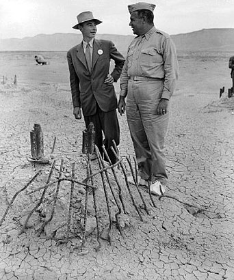 At the Trinity Test Site
In September 1945, many particpants returned to the Trinity Test site for news crews. Here Oppenheimer and Groves examine the remains of one the bases of the steel test tower. 
