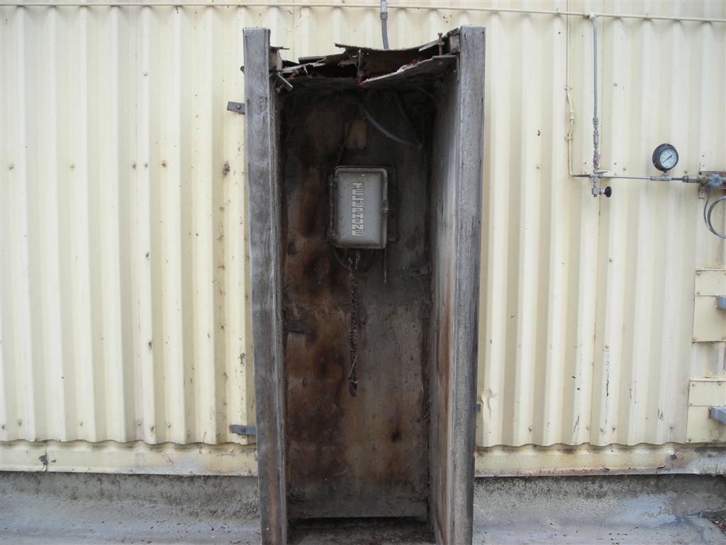 Superman's old phone booth perhaps?
It could also be a booth from the Matrix maybe..  
Today it sits on the 109 roof of N-Reactor.  Weather worn, it hasn't much time left before it too becomes rubble.
