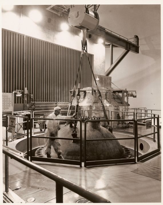 Showing the Head
Publicity photo from Consumers Power; accompanying caption reads: "Showing the 28-ton 'head,' or top, of Consumers Power Company's Nuclear Plant reactor itself.  The reactor in Michigan's first operating nuclear power plant rests below this head, which the plant operators remove at scheduled times for certain tests and maintenance work.  
"The plant is being used in a research and development program, and any of its 50,000 kilowatts of power not needed in the program is sent to Consumers Power Company's 900,000 electric customers in 61 counties throughout Michigan's Lower Peninsula."
Keywords: big rock point head reactor