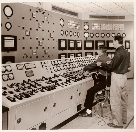 Big Rock Control Room
Publicity photo from Consumers Power; accompanying caption reads "In the 'brains' of a nuclear plant - the control room of Consumers Power Company's Big Rock Point Nuclear Plant, near Charlevoix.  Operators are timing the insertion and withdrawal of the 32 control rods in the reactor, a check made each time before each plant 'start-up.'  Directly in front of the men, a panel shows the location of the control rods inside the core of the reactor."
Keywords: big rock point control room
