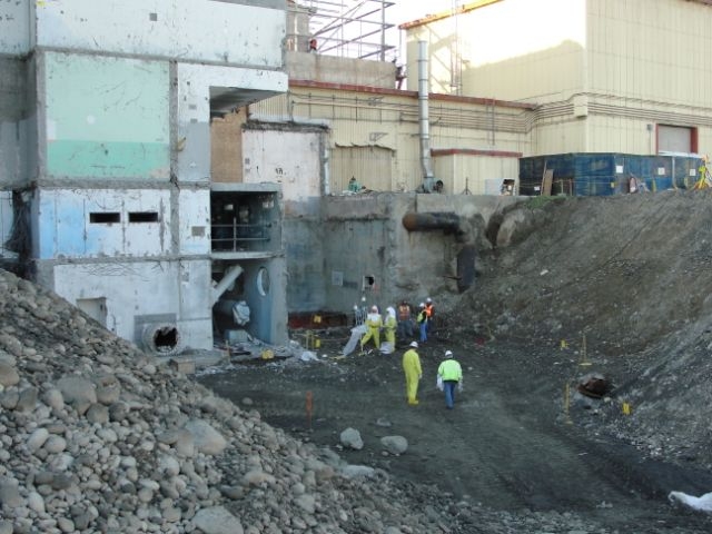 105N, looking plant S
The bottom of the excavation and back in the corner.  The hole accesses the lift station and the workers are entering to obtain samples of the lift station's floor for future use in demo.
